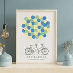 Close-up of tandem bicycle guest book with personalized couple’s names and wedding date under colorful balloon signatures