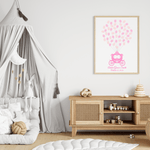Framed princess fingerprint guest book with pink carriage and balloon prints, hanging above a crib in a soft pastel nursery.