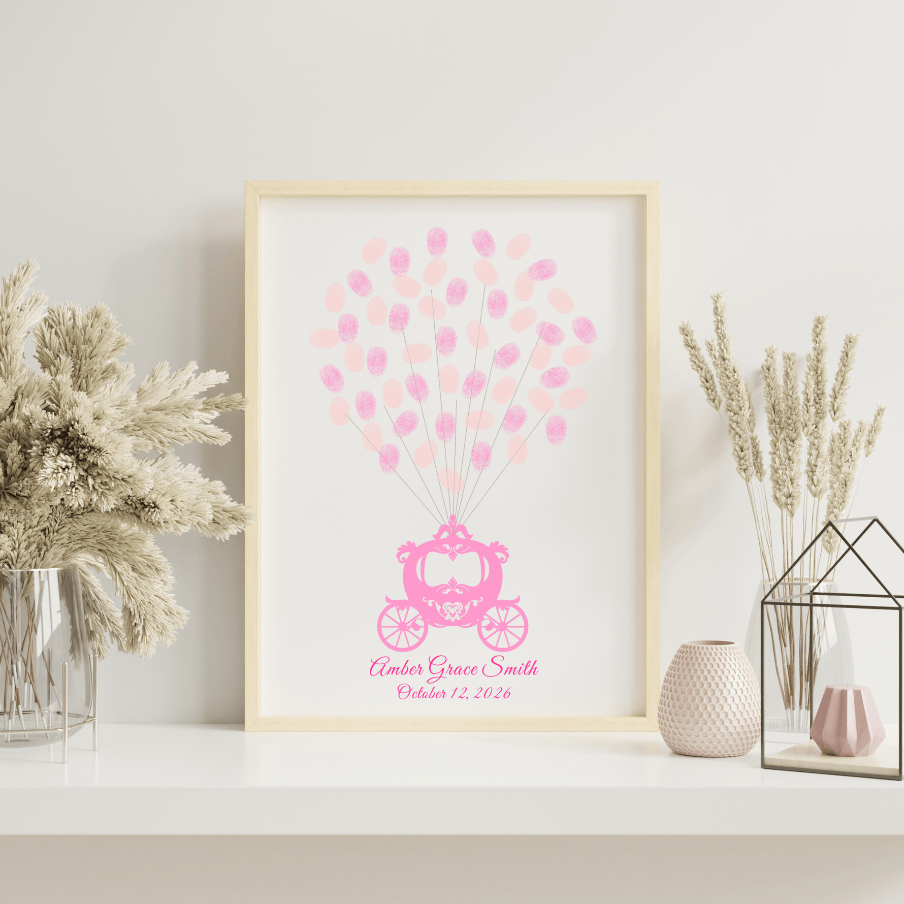Whimsical baby shower guest book with fingerprint balloons in a white frame, styled on a shelf in a princess-themed baby room.