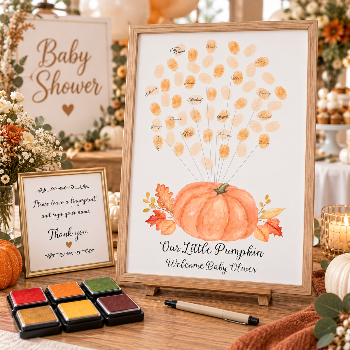 Orange pumpkin balloon fingerprint guest book displayed at a baby shower