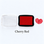 Cherry red fingerprint guest book ink pad beside a heart-shaped sample print