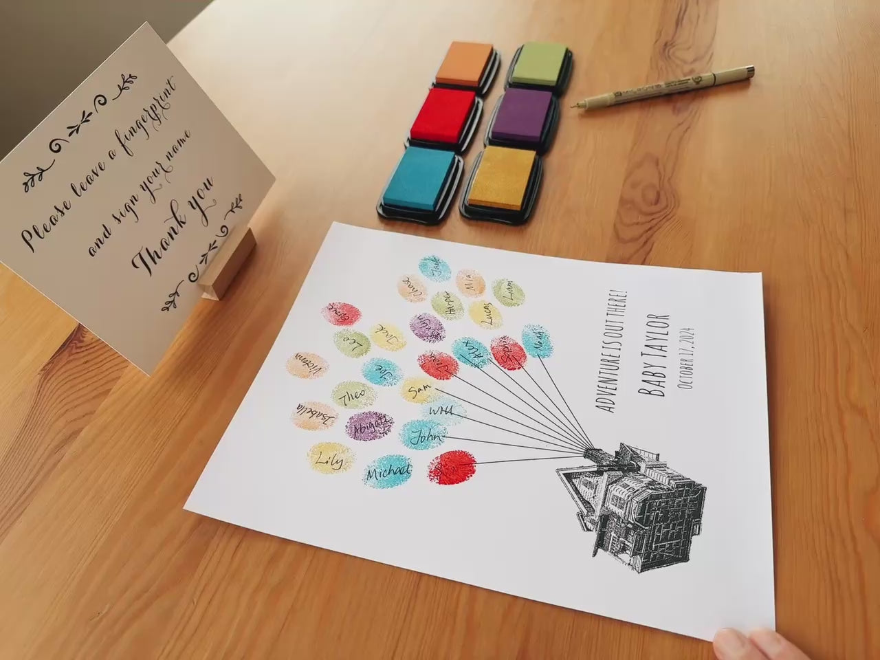 Demo showing guests adding fingerprints to an Up house balloon guest book